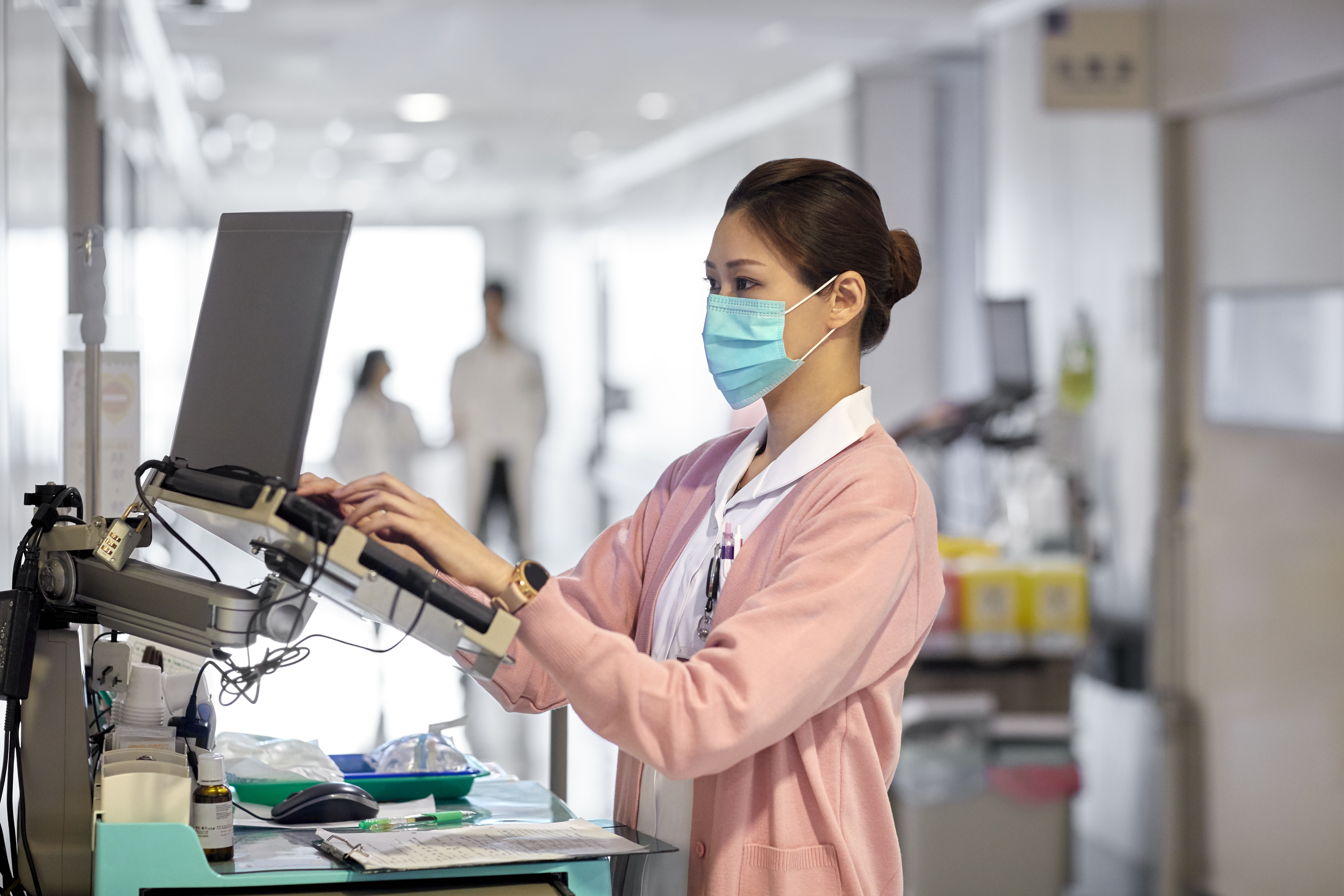 Asian female doctor working at a laptop station