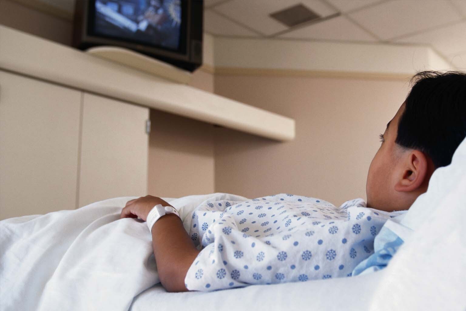 young boy in hospital bed watching television