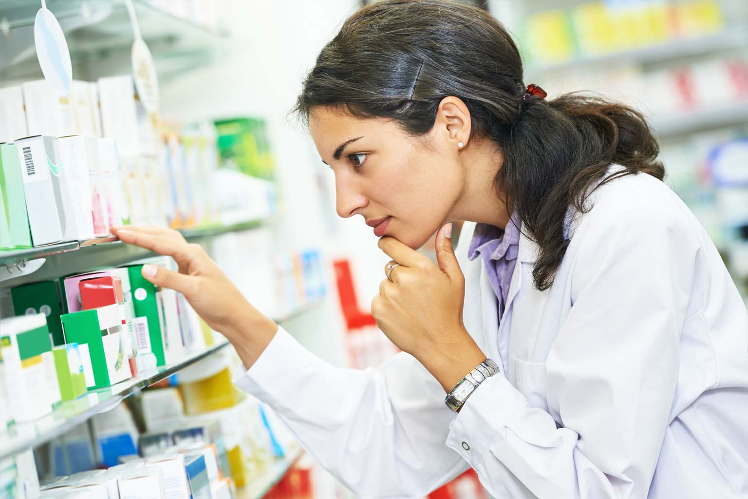 pharmacist examining medication in pharmacy