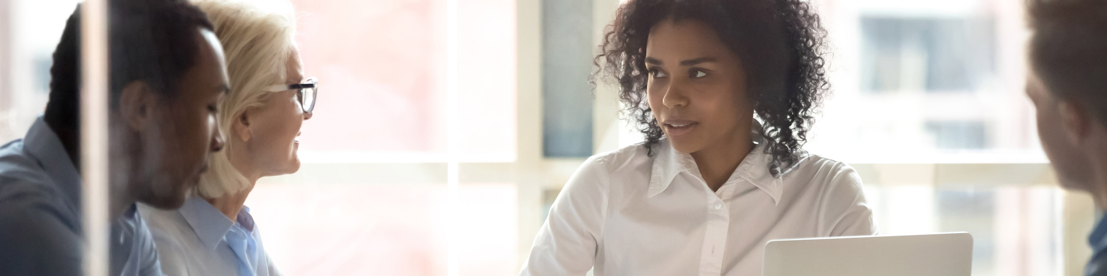 Serious african american female leader talking at diverse group boardroom meeting, multi-ethnic team people employees discussing deal benefits, negotiating on business contract terms with clients