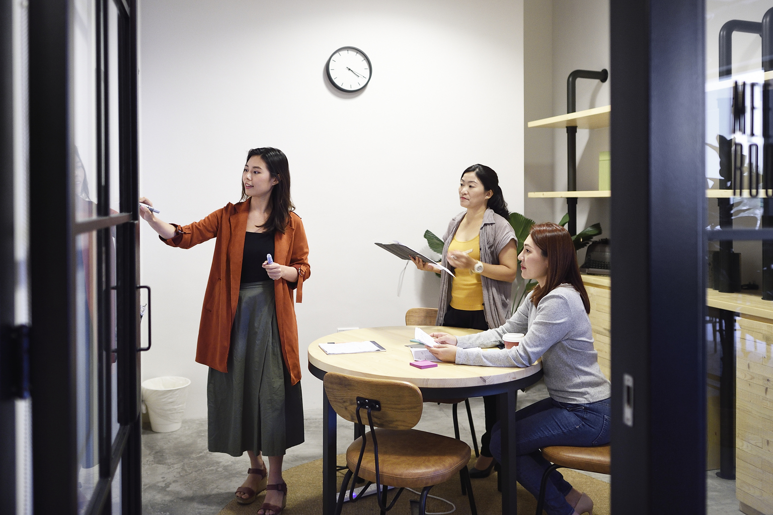 Chinese women brainstorming in an office at night