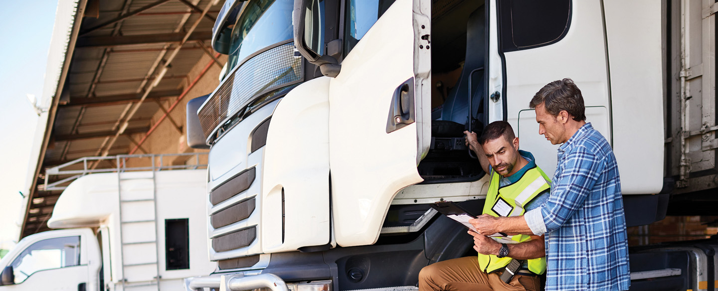 two men discussing vehicle title management of large trucks