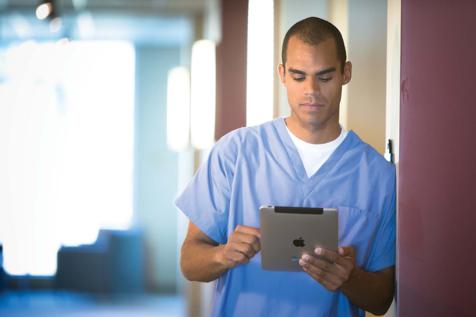 doctor paused in hallway looking at tablet