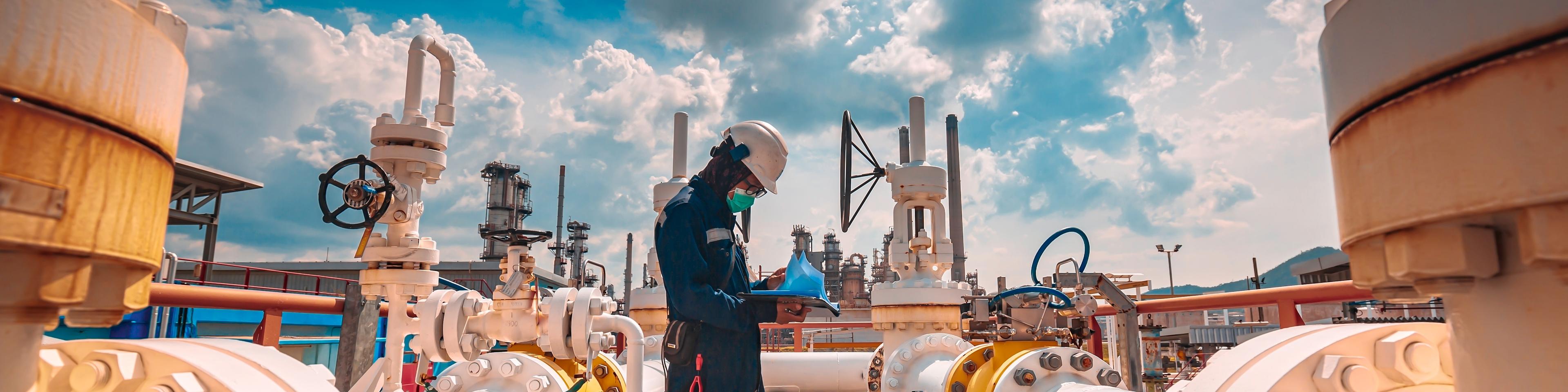 Male worker inspection at steel long pipes and pipe elbow in station oil factory during refinery valve of visual check record pipeline tank oil and gas industry