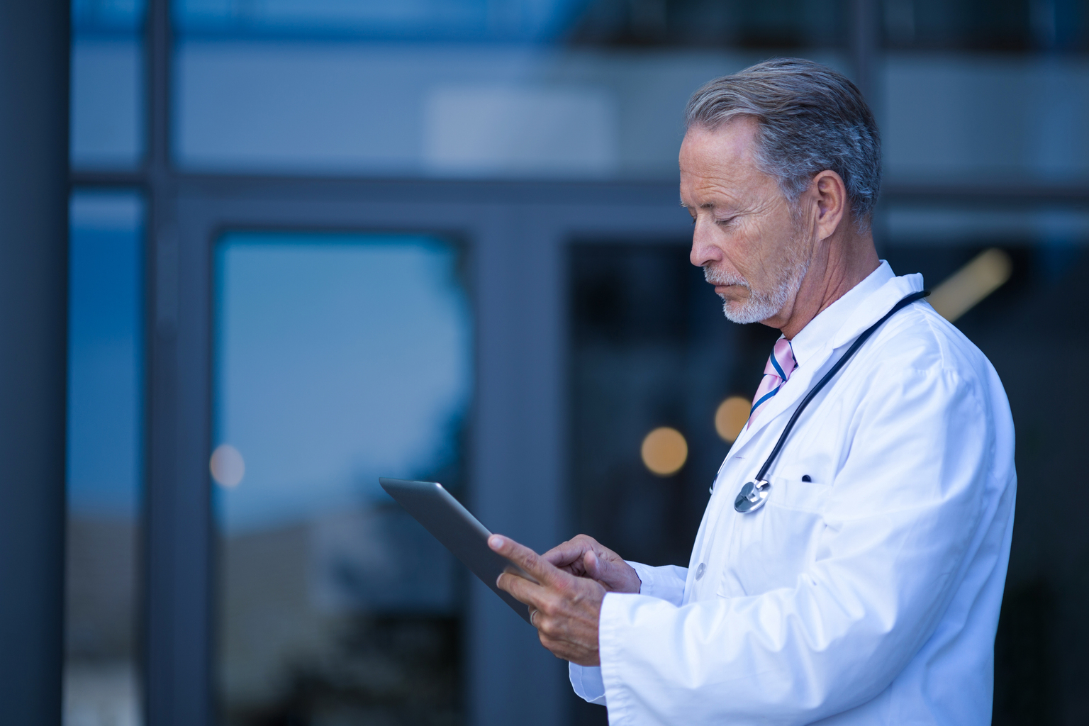 Male physician using digital tablet