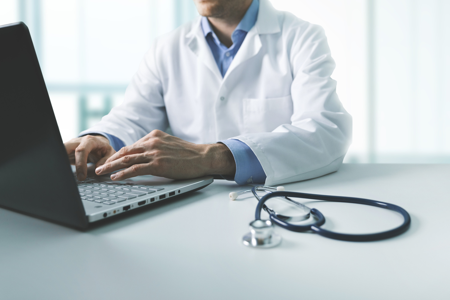 Doctor working on laptop computer in clinic office