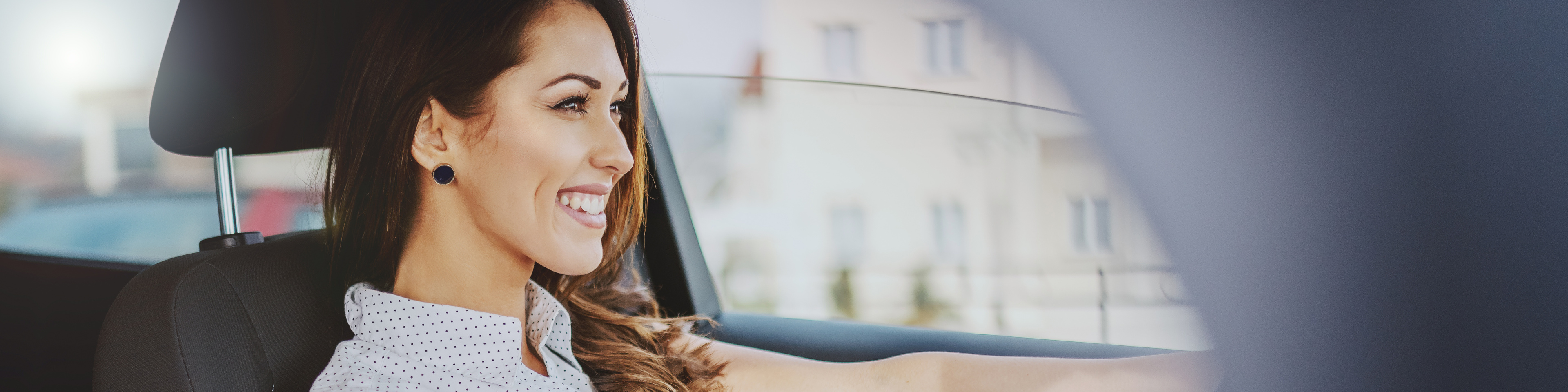 Woman in front seat of Nissan car