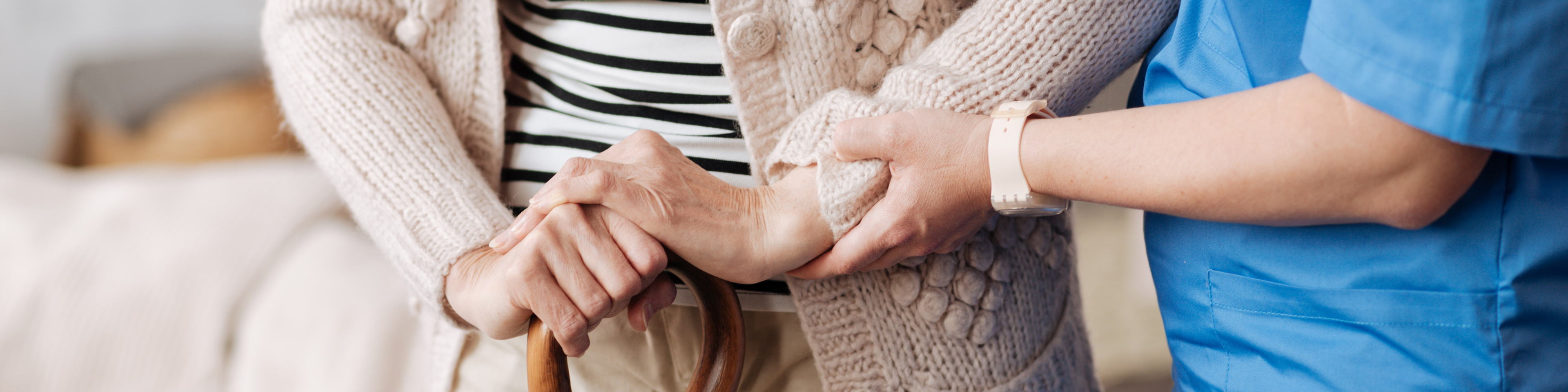 Gentle trained nurse helping cane-using mature patient