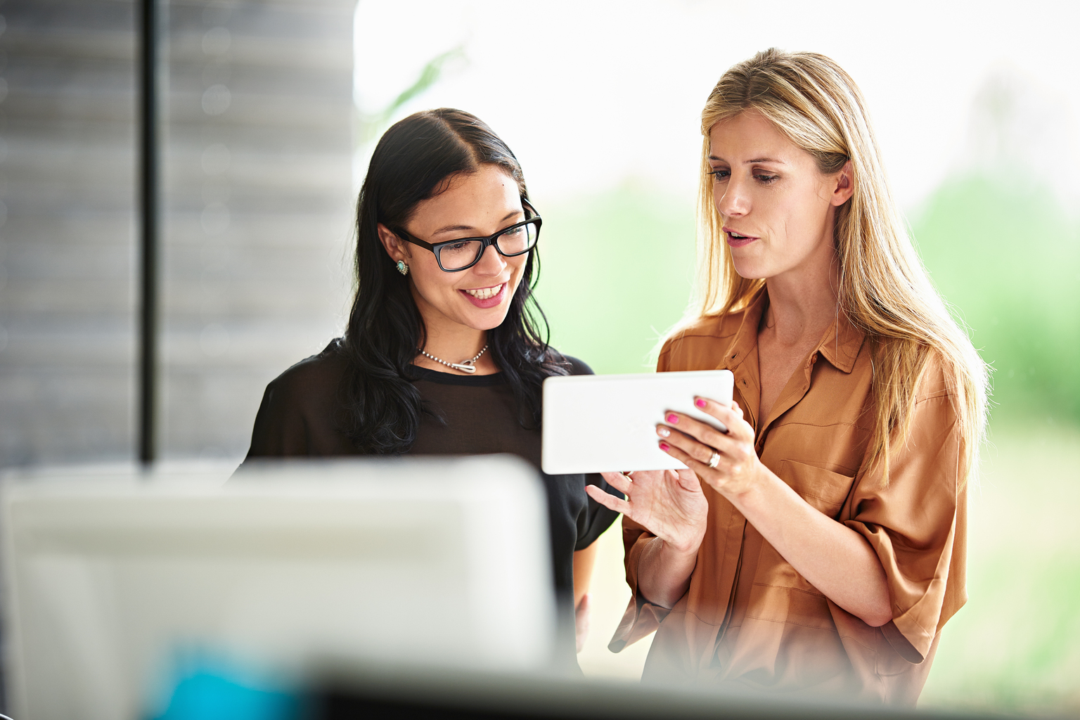 Two Business woman discussing over a device