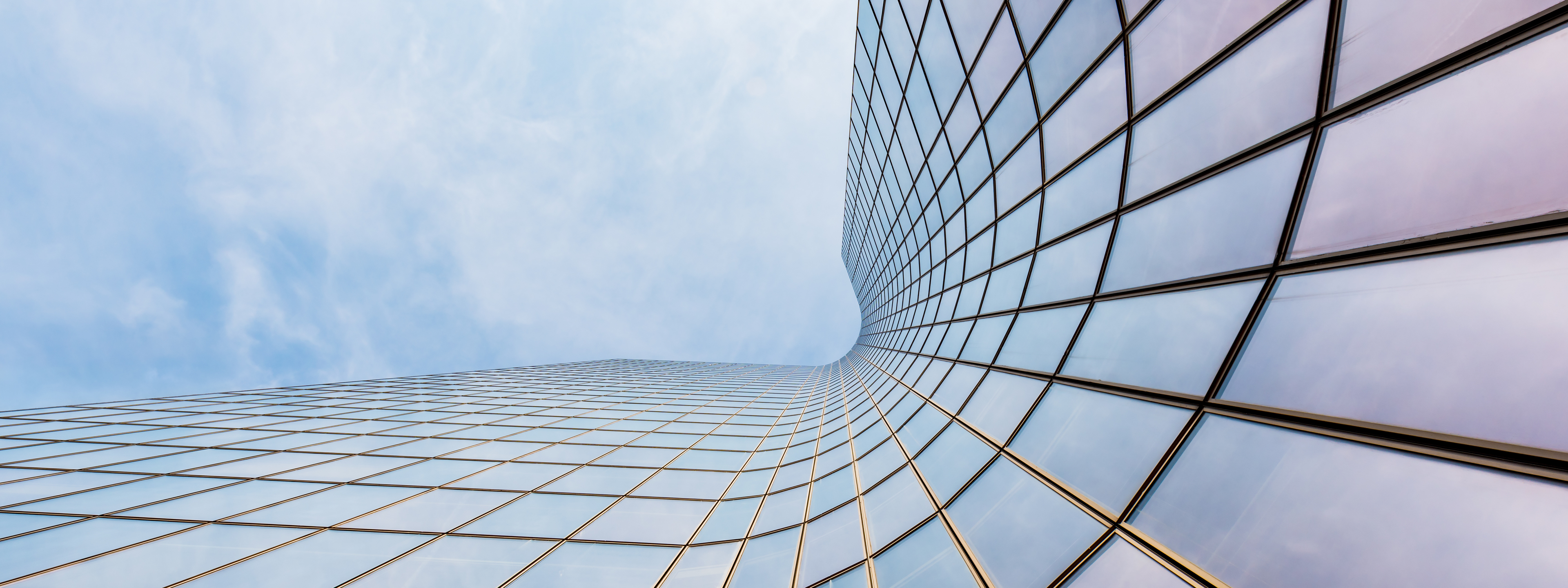 Curved skyscraper against blue sky,