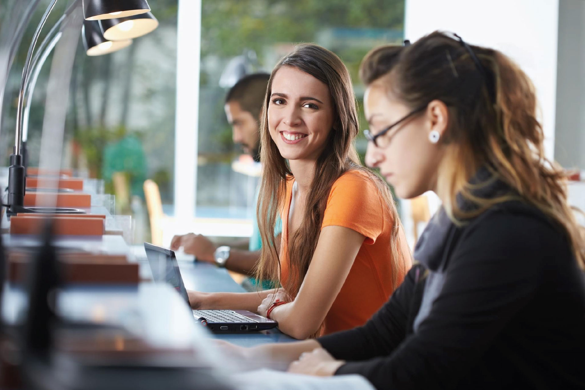 Uśmiechnięta studentka korzysta z LEX Student na laptopie