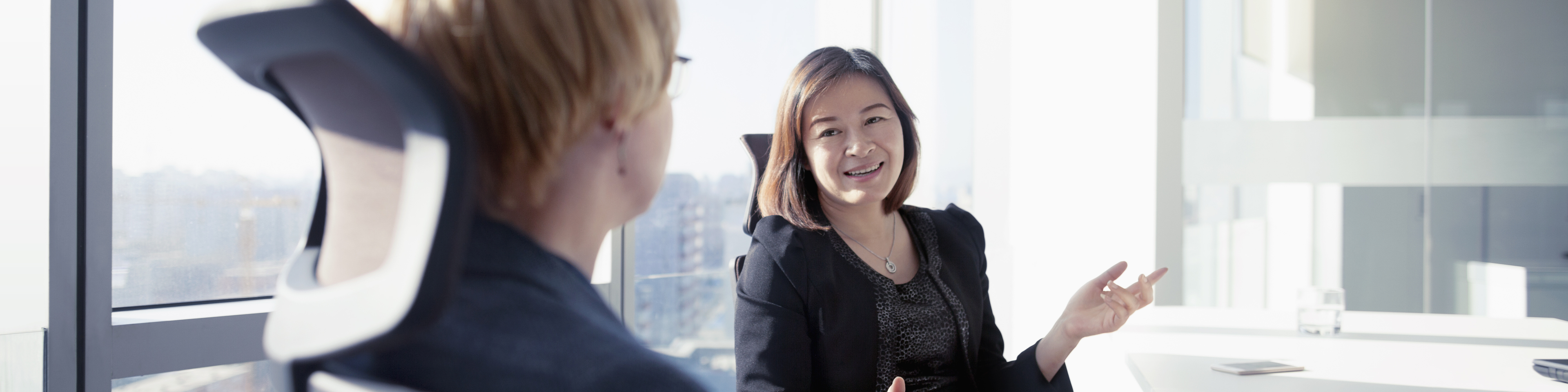 Business women talking together in meeting room