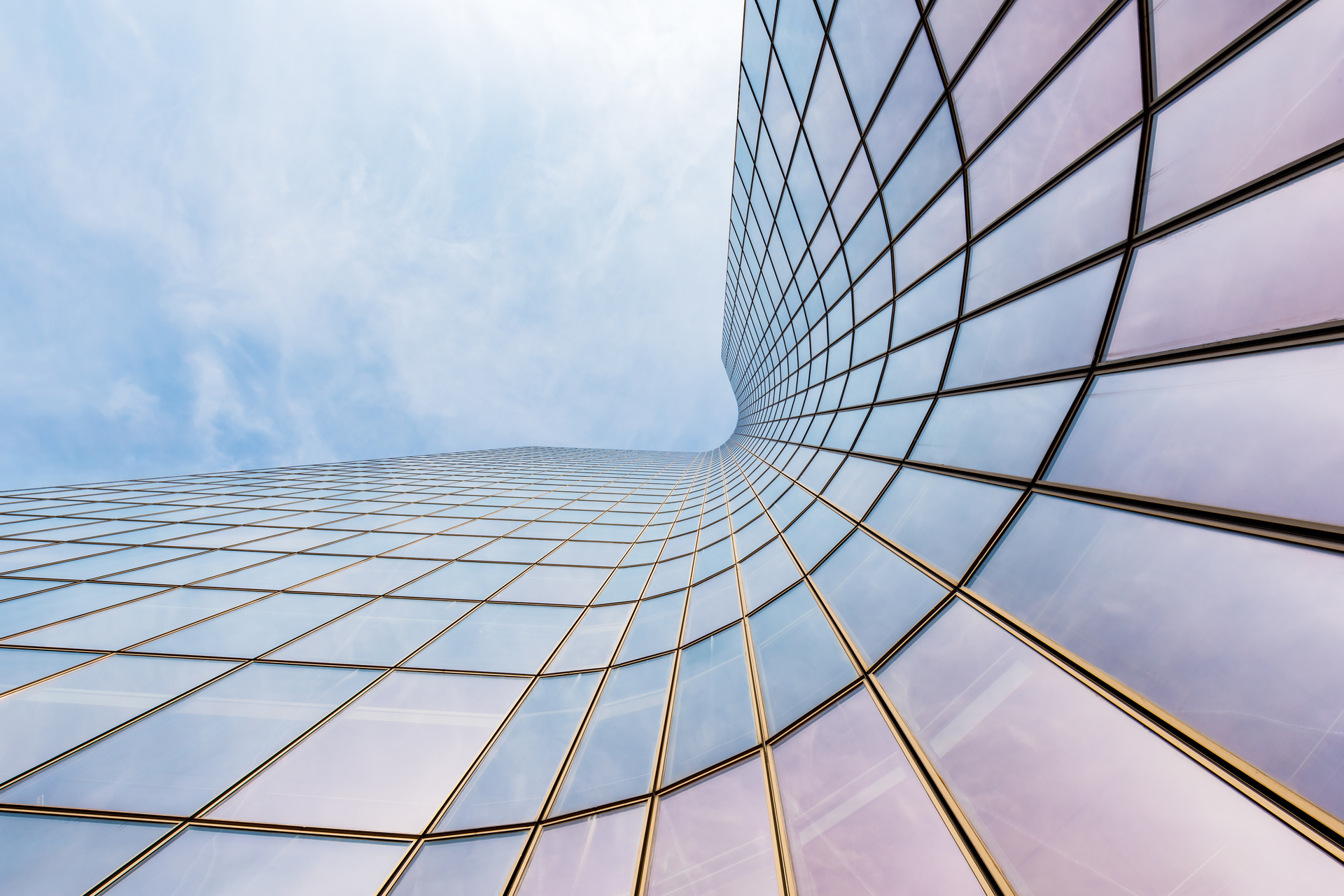 Curved skyscraper against blue sky,