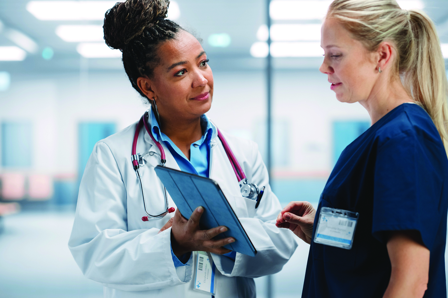 Two medical professionals reviewing data on tablet