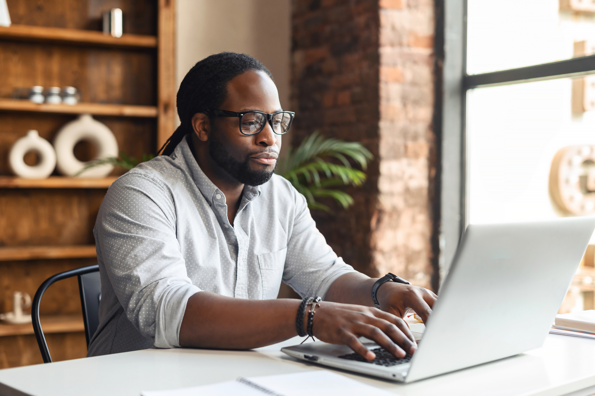 Author working at laptop next to window