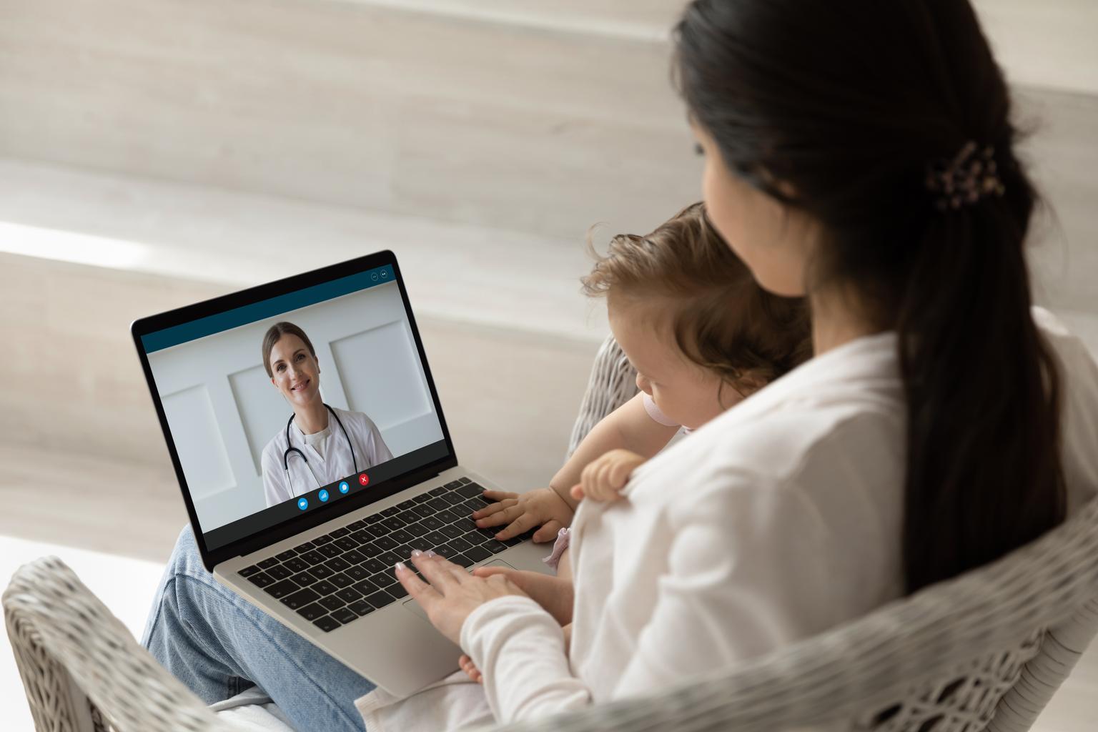 Mother and child sitting together on a telehealth call with healthcare professional