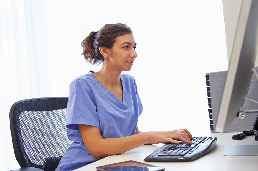 Female healthcare provider working at computer in office