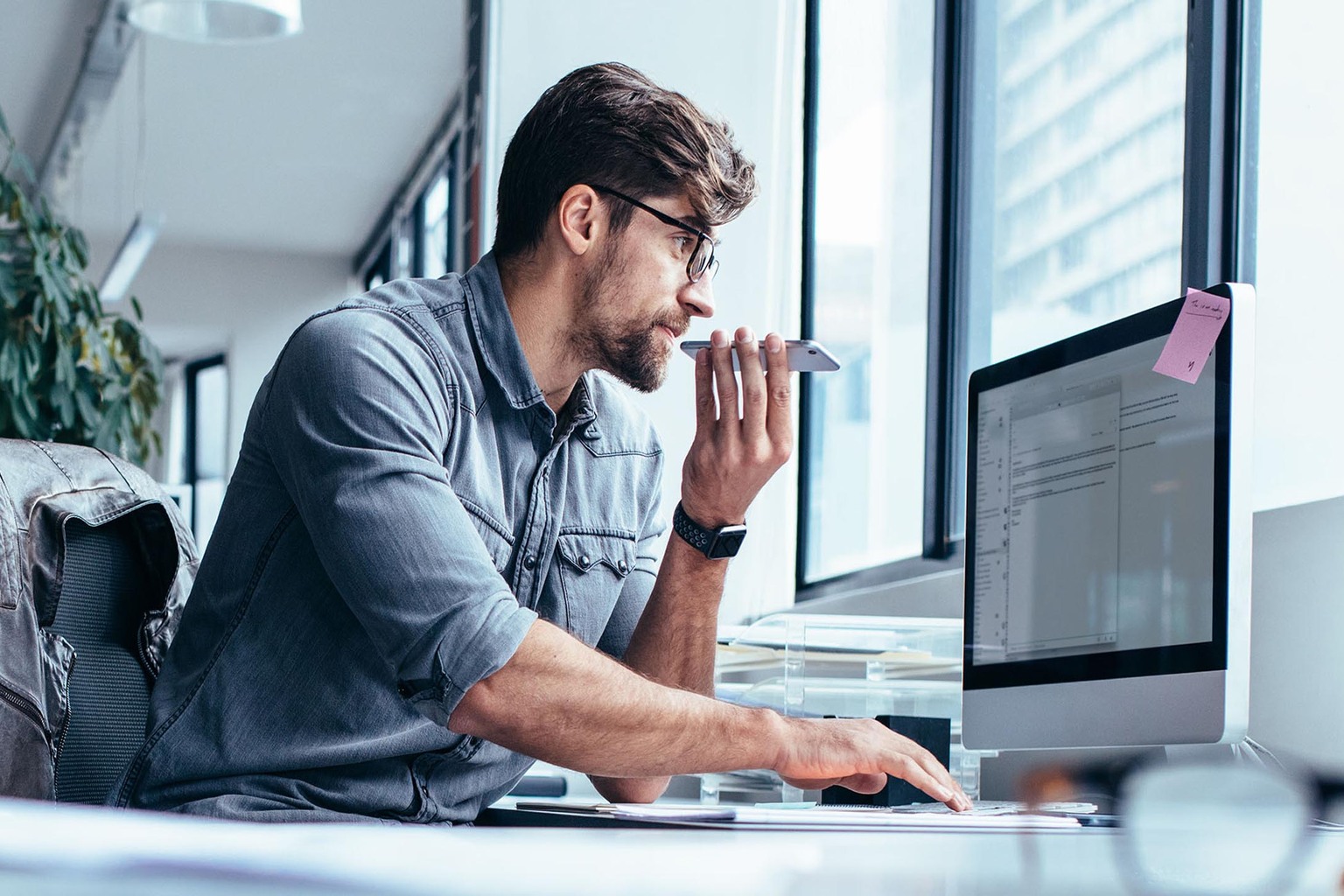 guy behind the computer in an open office space