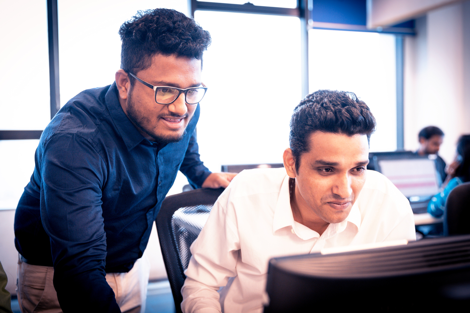 Two Indian employees discussing over a laptop