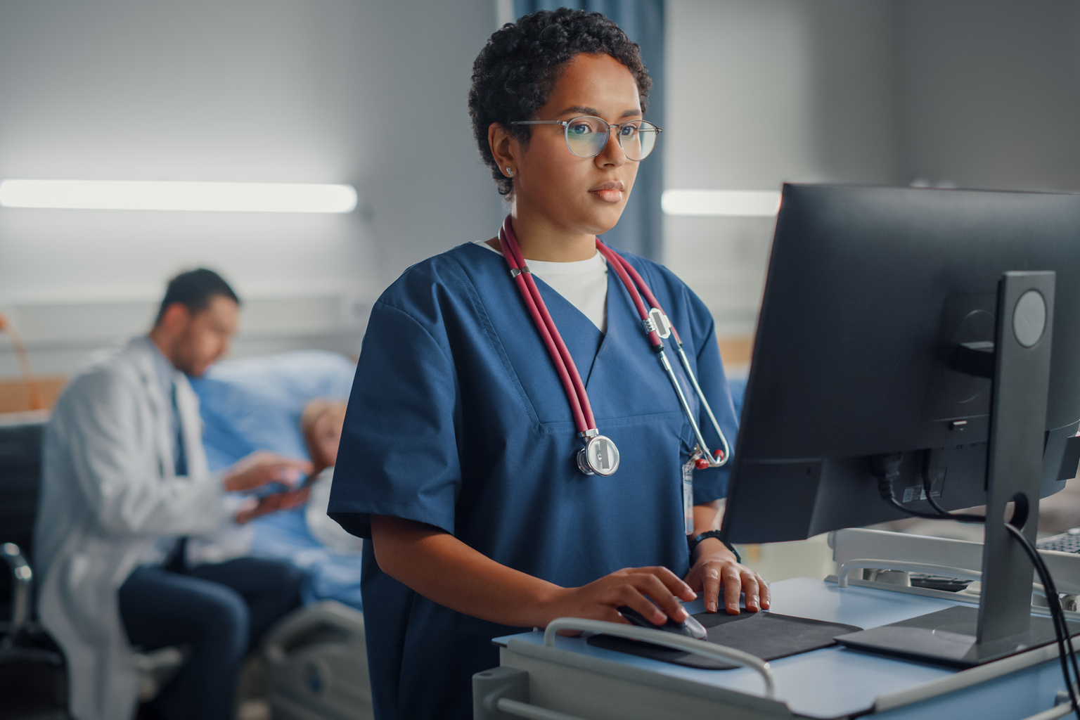 Nurse reviewing EHR on mobile charting station