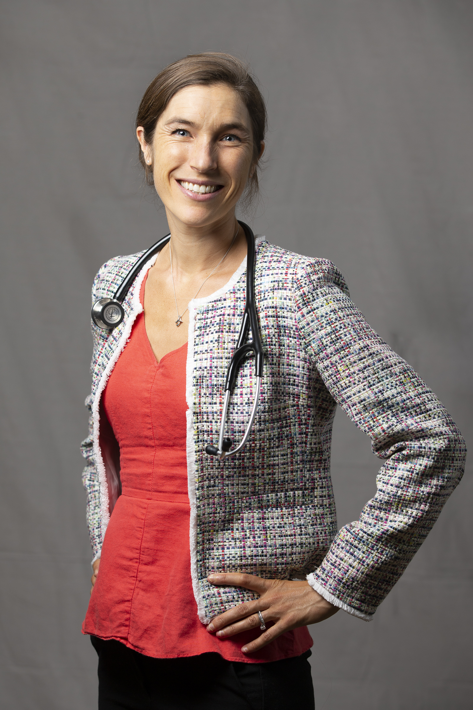 Dr. Wakeman wearing orange shirt with textured blazer, stethoscope worn on neck