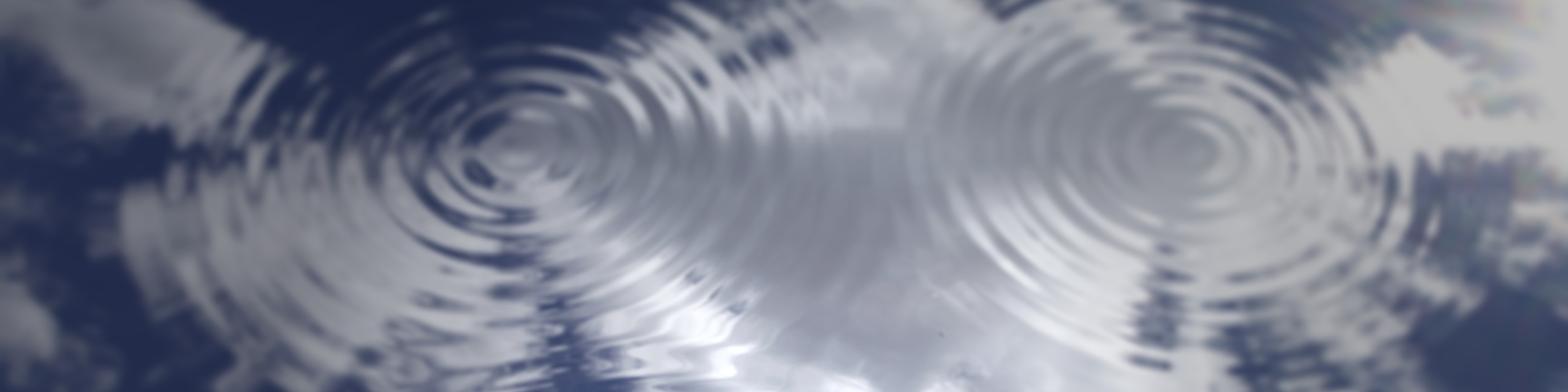 Full frame shot of water surface reflecting dramatic blue sky