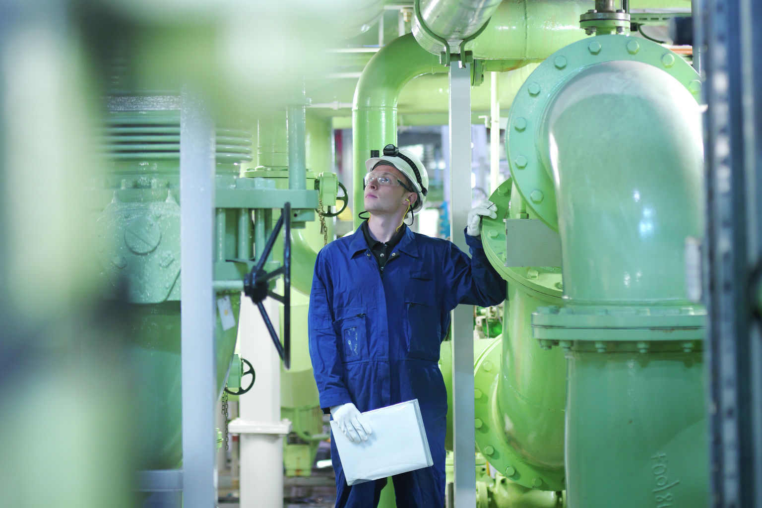 An engineer in hard-hat inspecting fuel and power generation machines