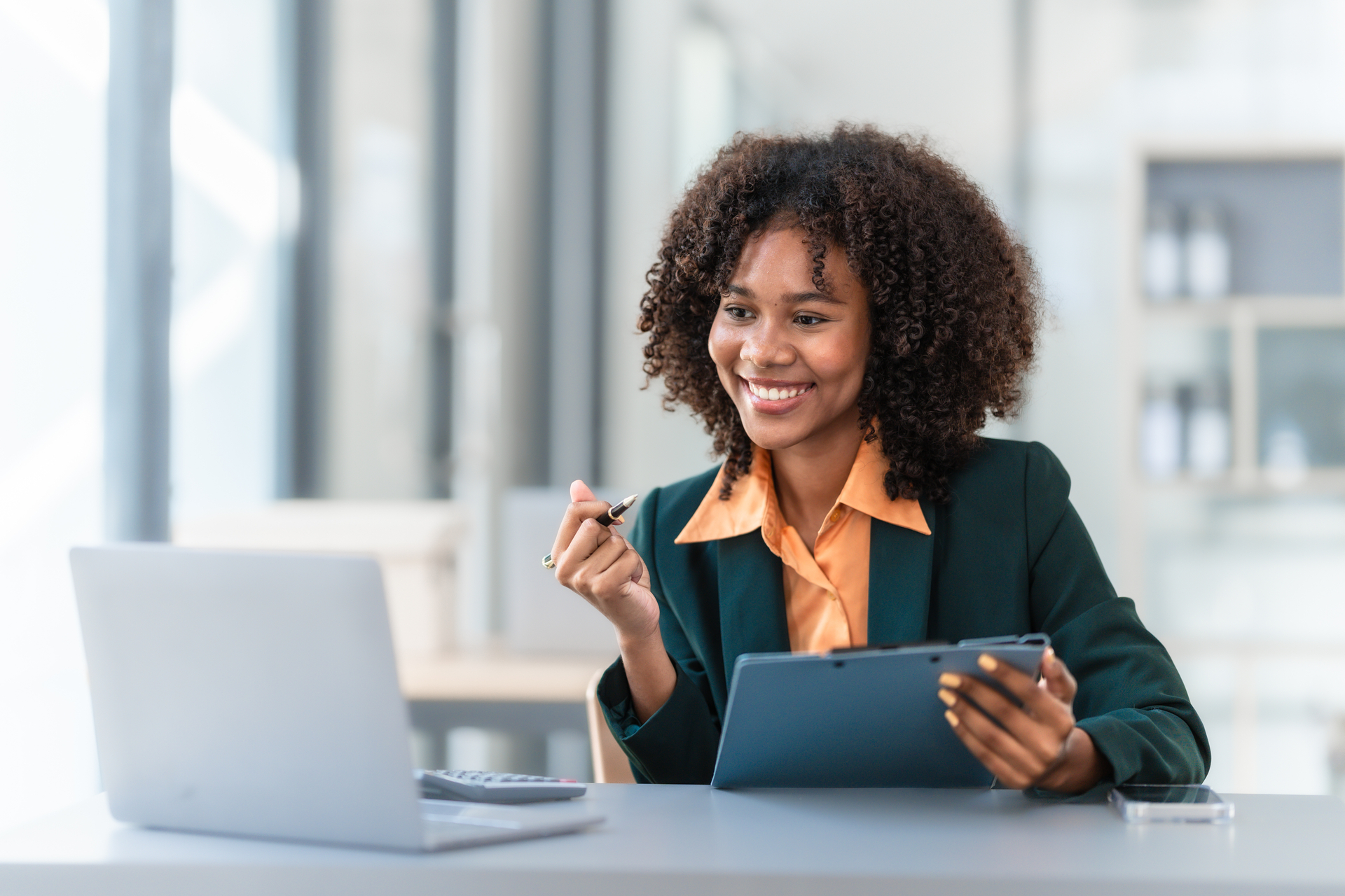 Happy businesswoman looking at her laptop