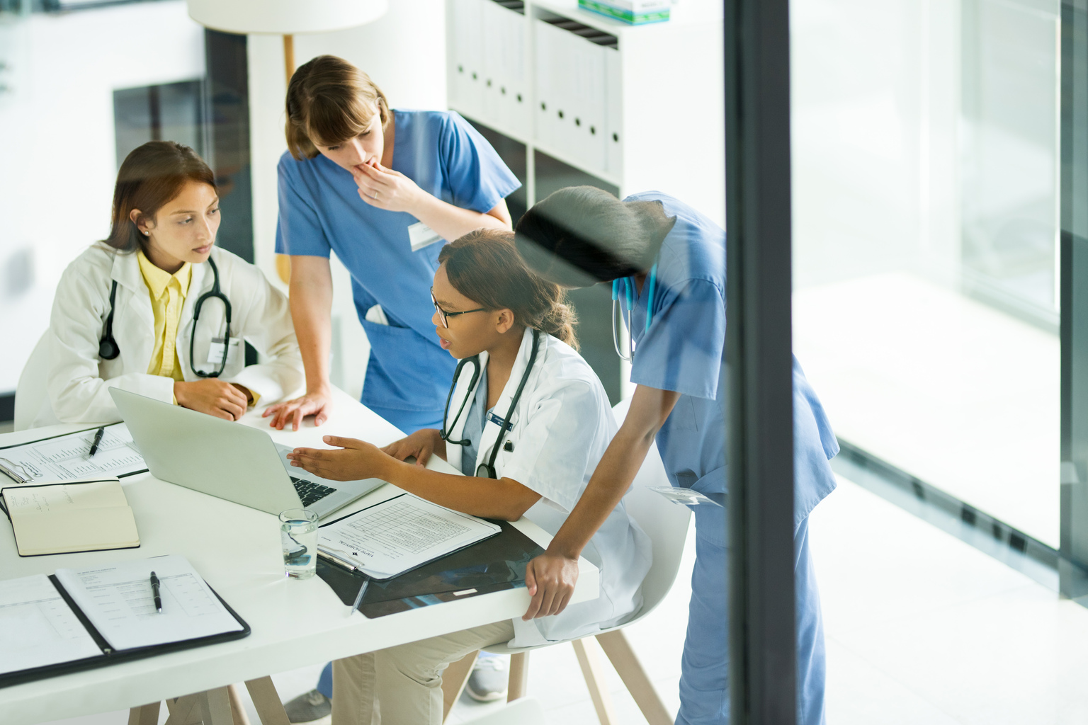 Group of medical practitioners working together on a laptop