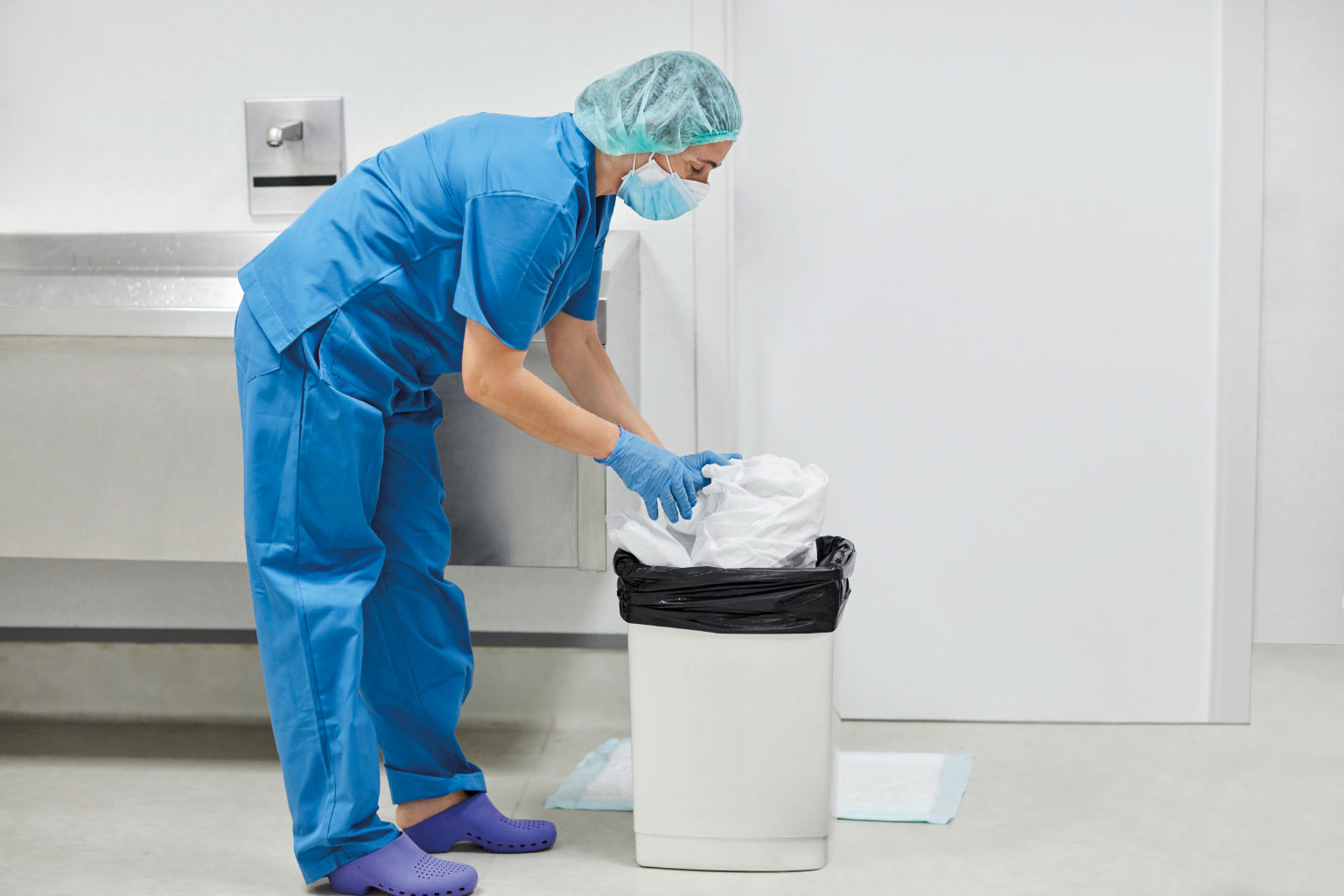 Pielęgniarka wyrzuca odpady medyczne na bloku operacyjnym
