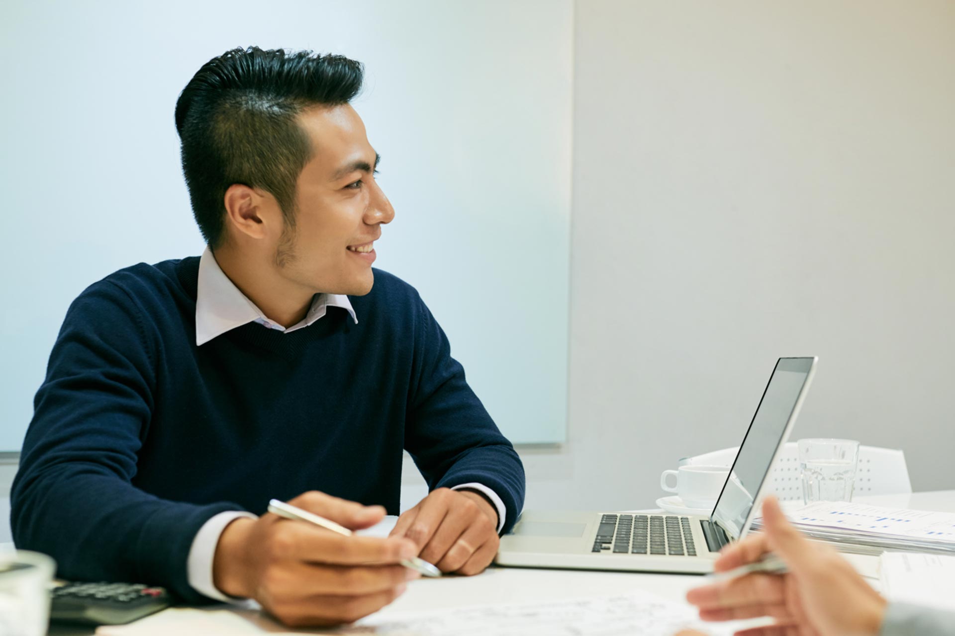 Man smiling and signing documents