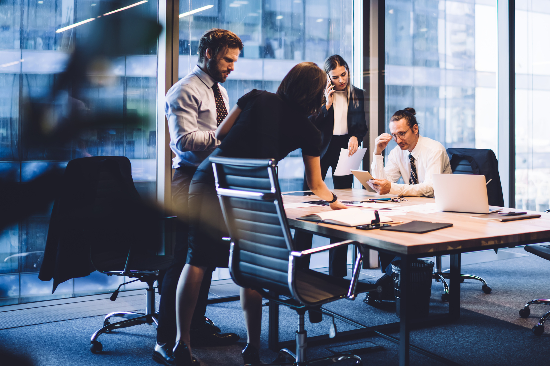 Cooperation process of professional male and female colleagues,business woman in formal suit communicate with operator via smartphone gadget while reading email from partners touch pad during teamwork