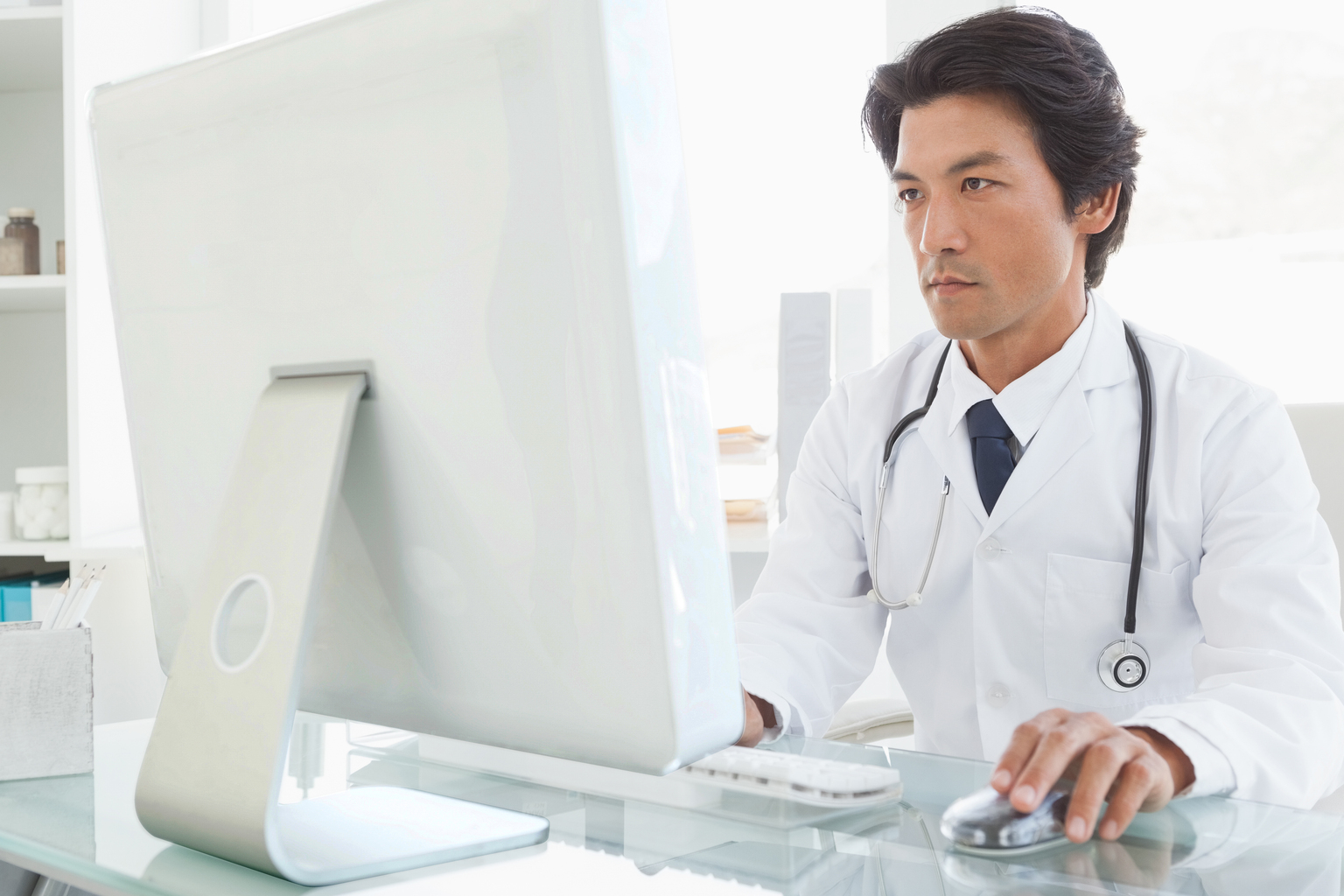 Serious Japanese male doctor using the computer