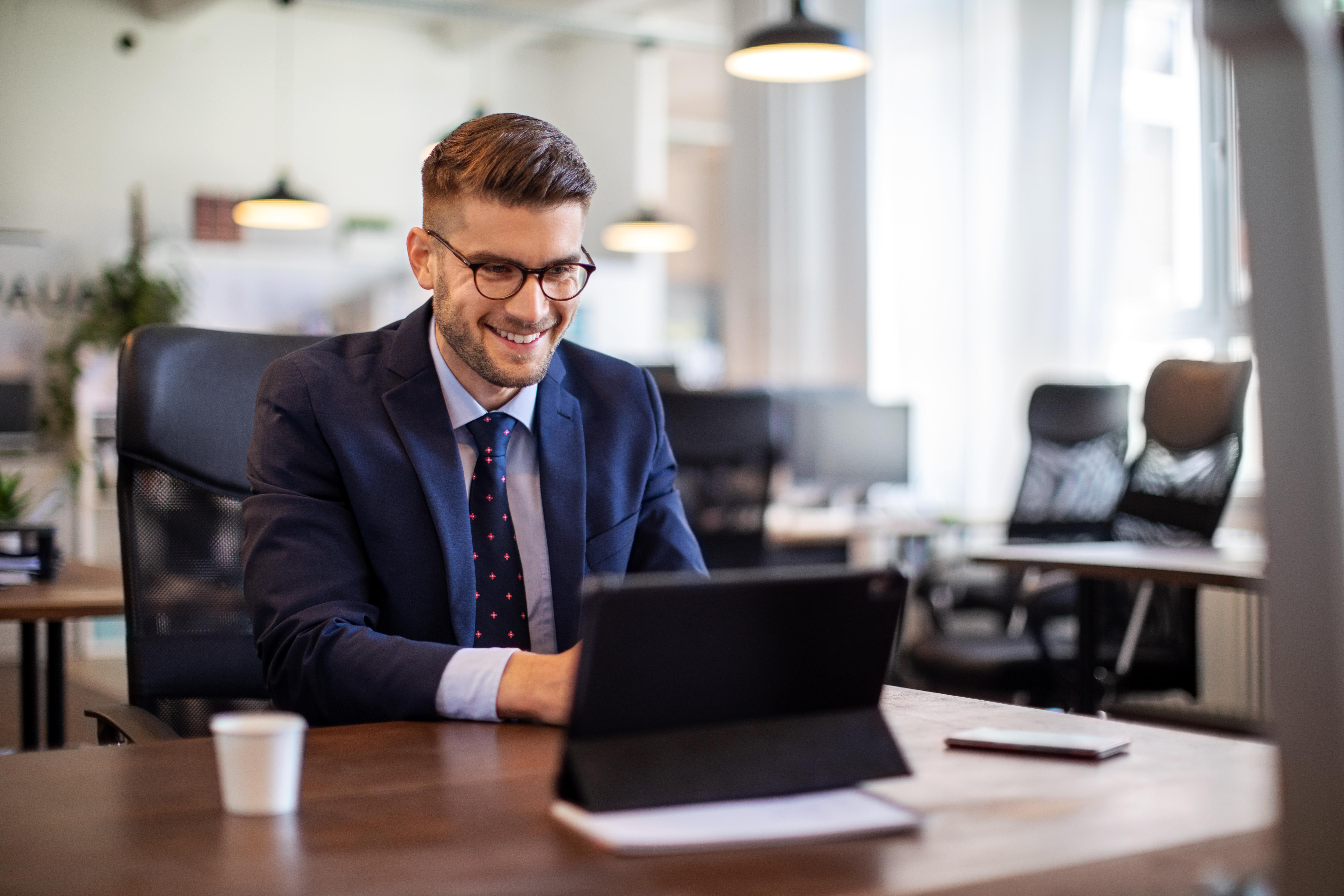 Business man smiling and working on Laptop