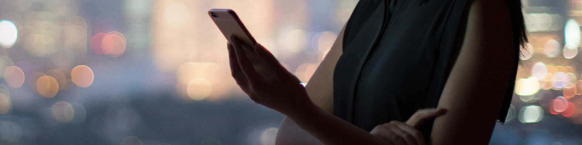 woman reviews smartphone over skyline