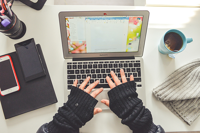 Birdseye view of gloved woman working on a laptop