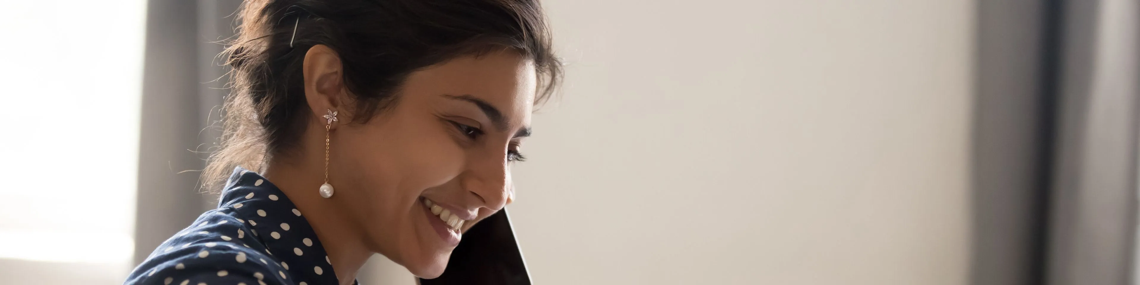 Smiling-employee-working-on-laptop-talking-over-phone