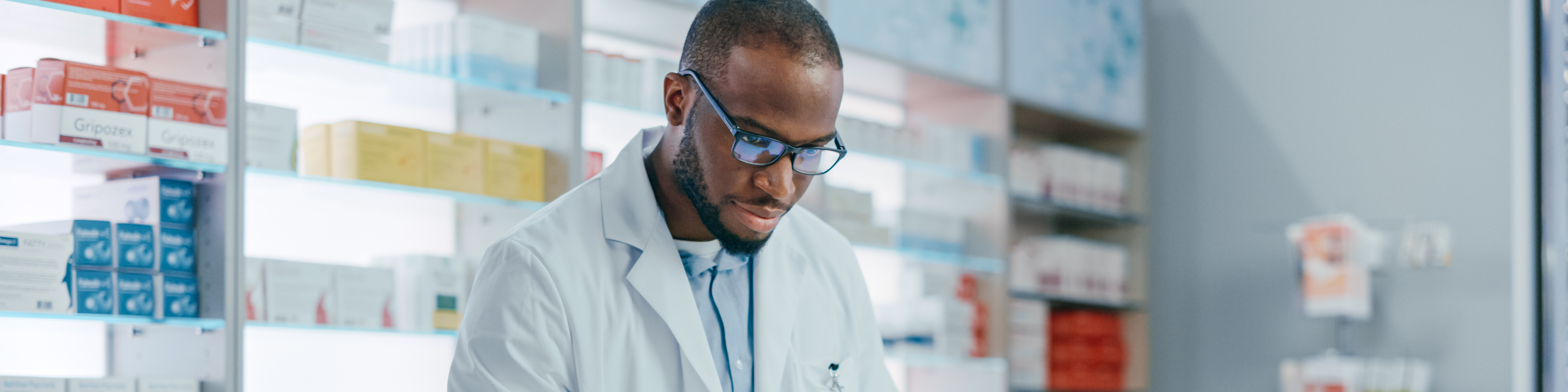 Pharmacist working on computer at pharmacy drugstore checkout counter