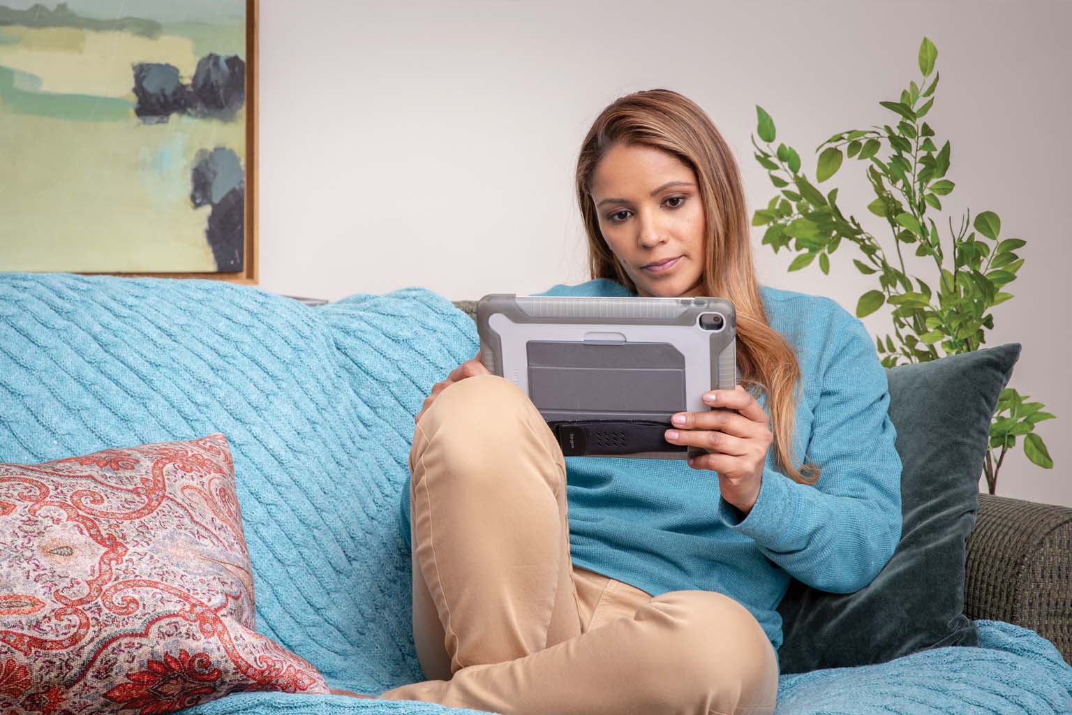 female crosslegged on couch with tablet