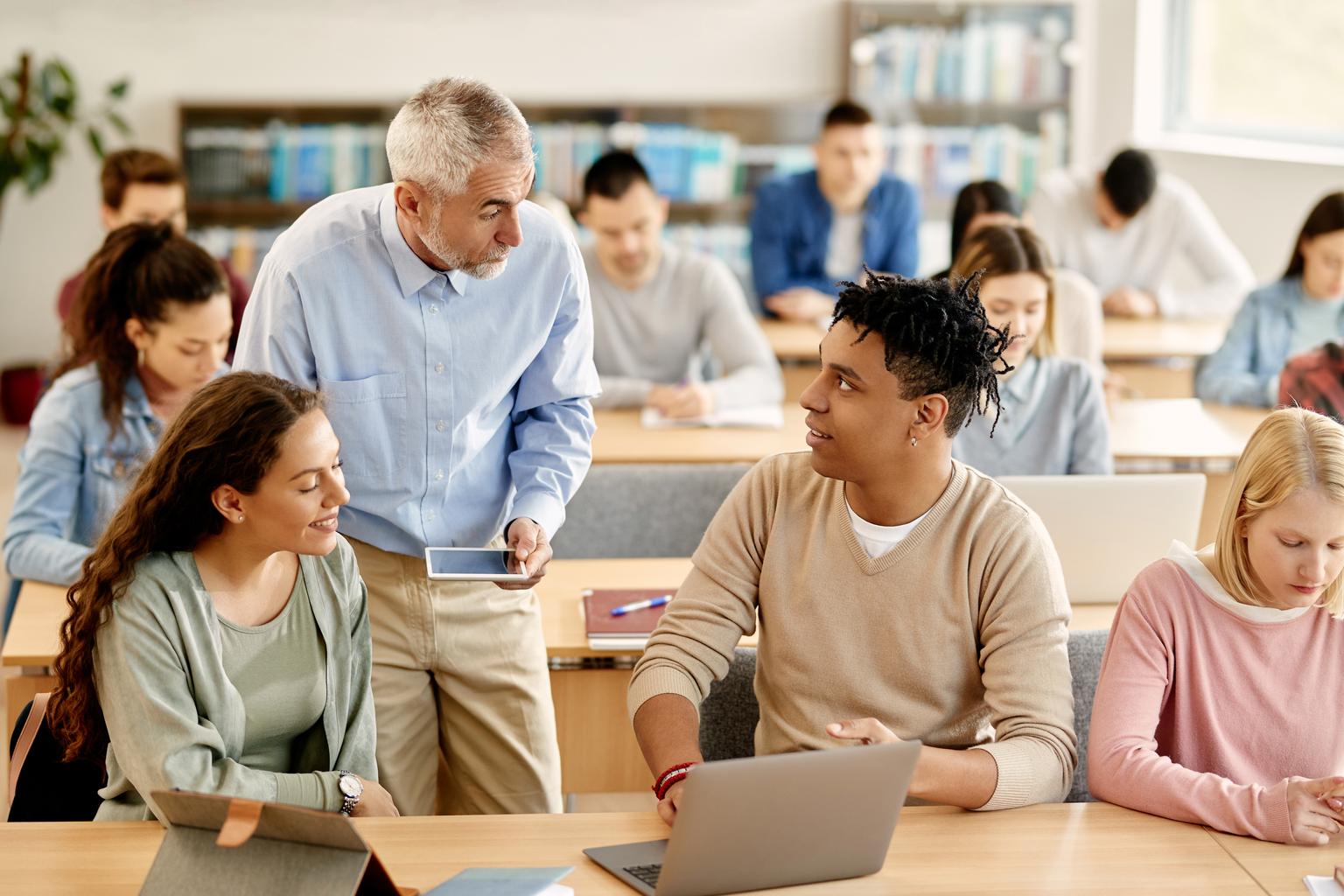 Professor assisting medical students with classroom assignments