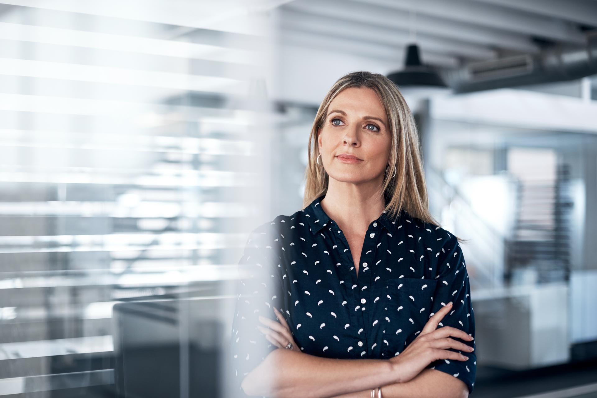 Geschäftsfrau in einem modernen Büro blickt nachdenklich 