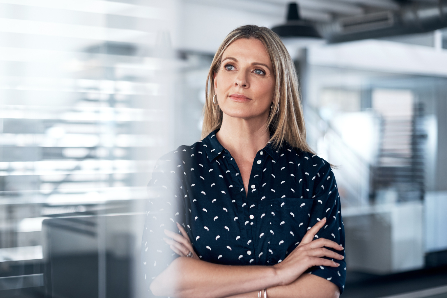 Geschäftsfrau in einem modernen Büro blickt nachdenklich 