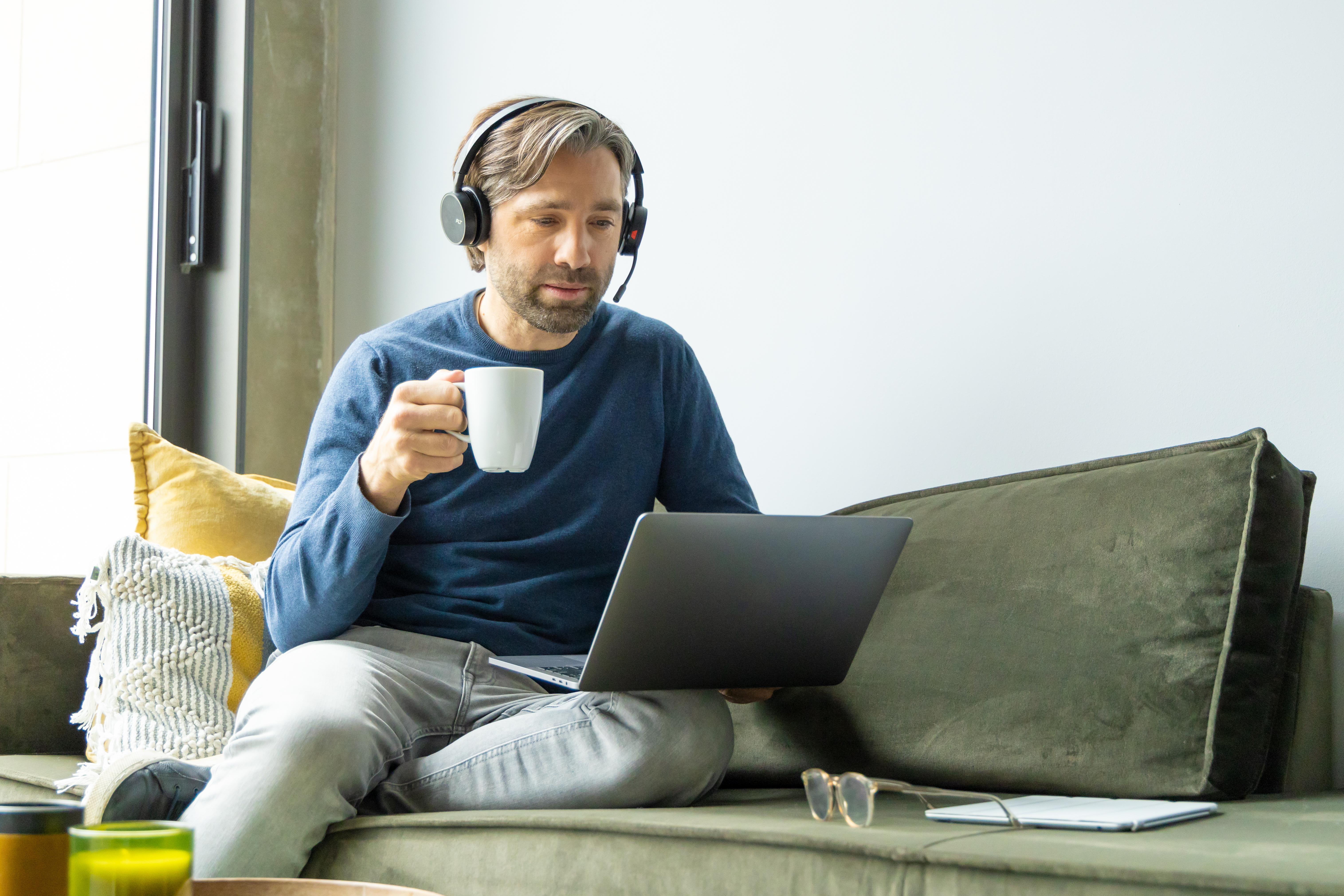 man drinks a coffee during an online meeting 