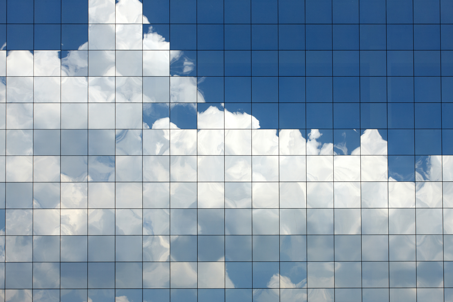 Clouds reflected in windows of modern office building