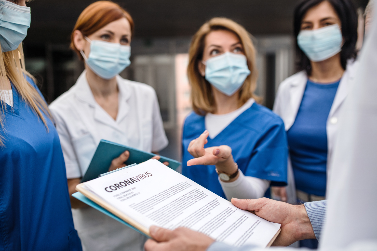 Group of nurses and doctors together discussing coronavirus