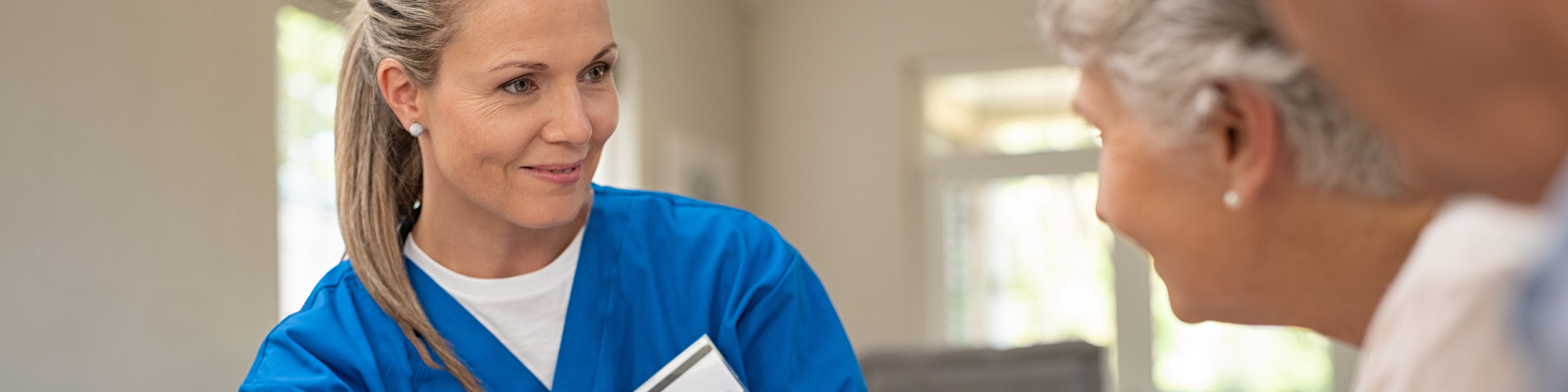 Friendly nurse talking with older couple