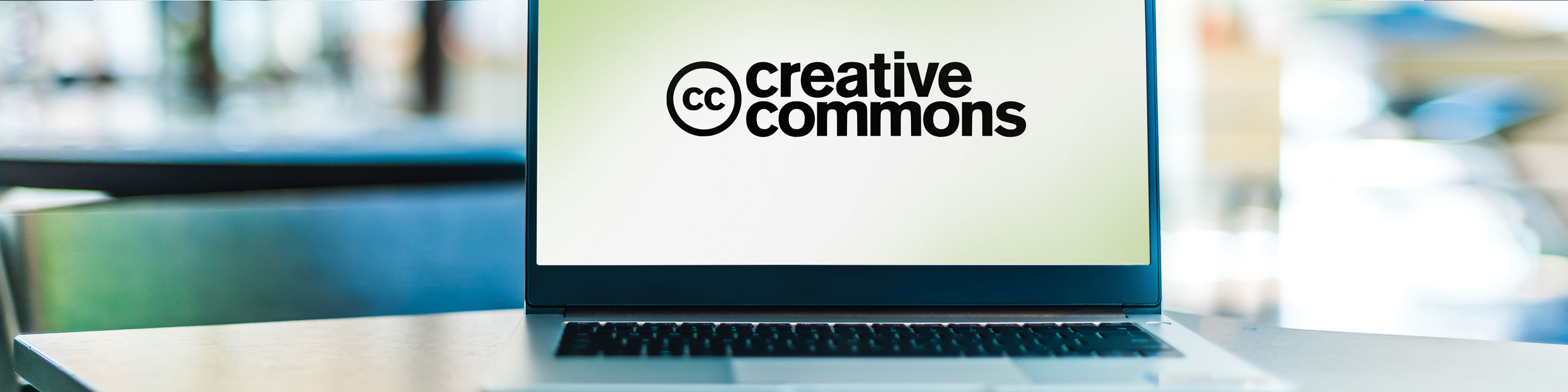 Laptop sitting on a table displaying the Creative Commons logo