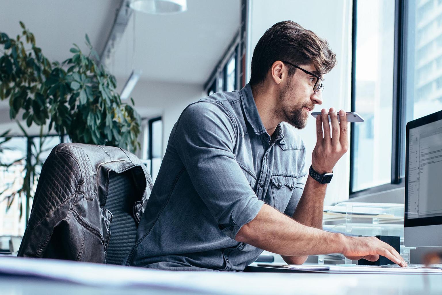 guy behind the computer in an open office space