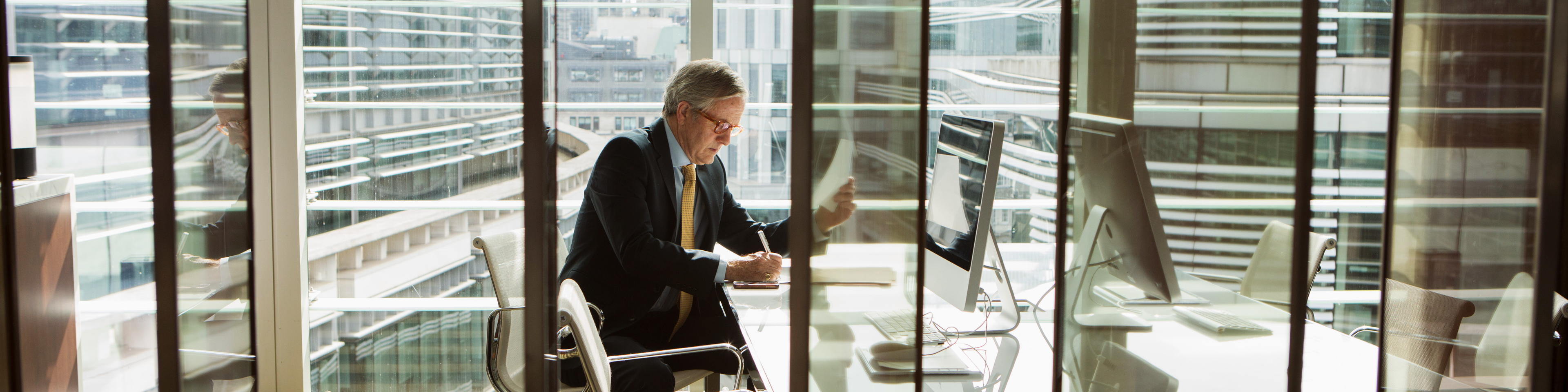 Businessman reading and analysing report, London, UK