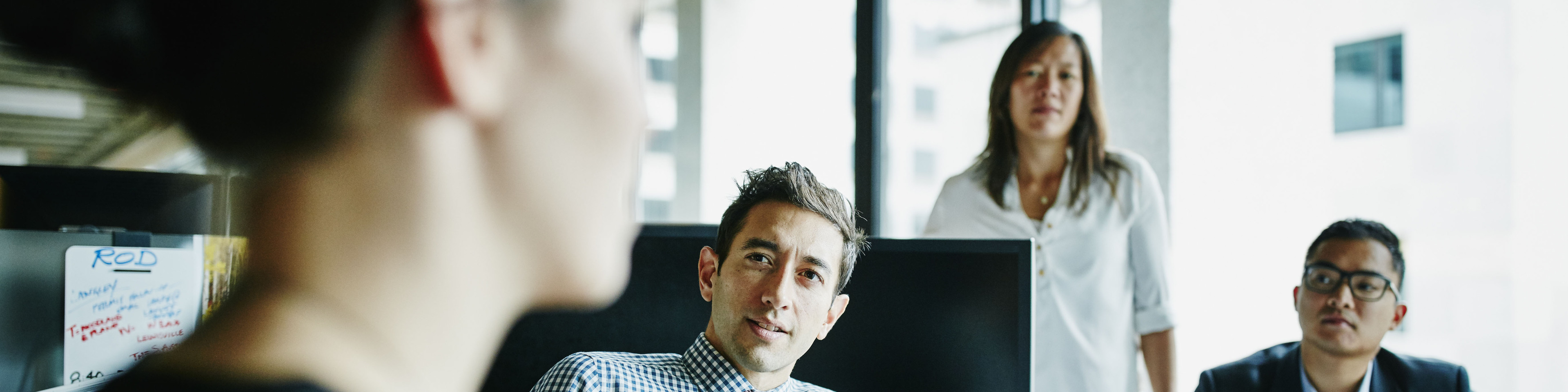 Businesswoman leading team meeting with coworkers in office